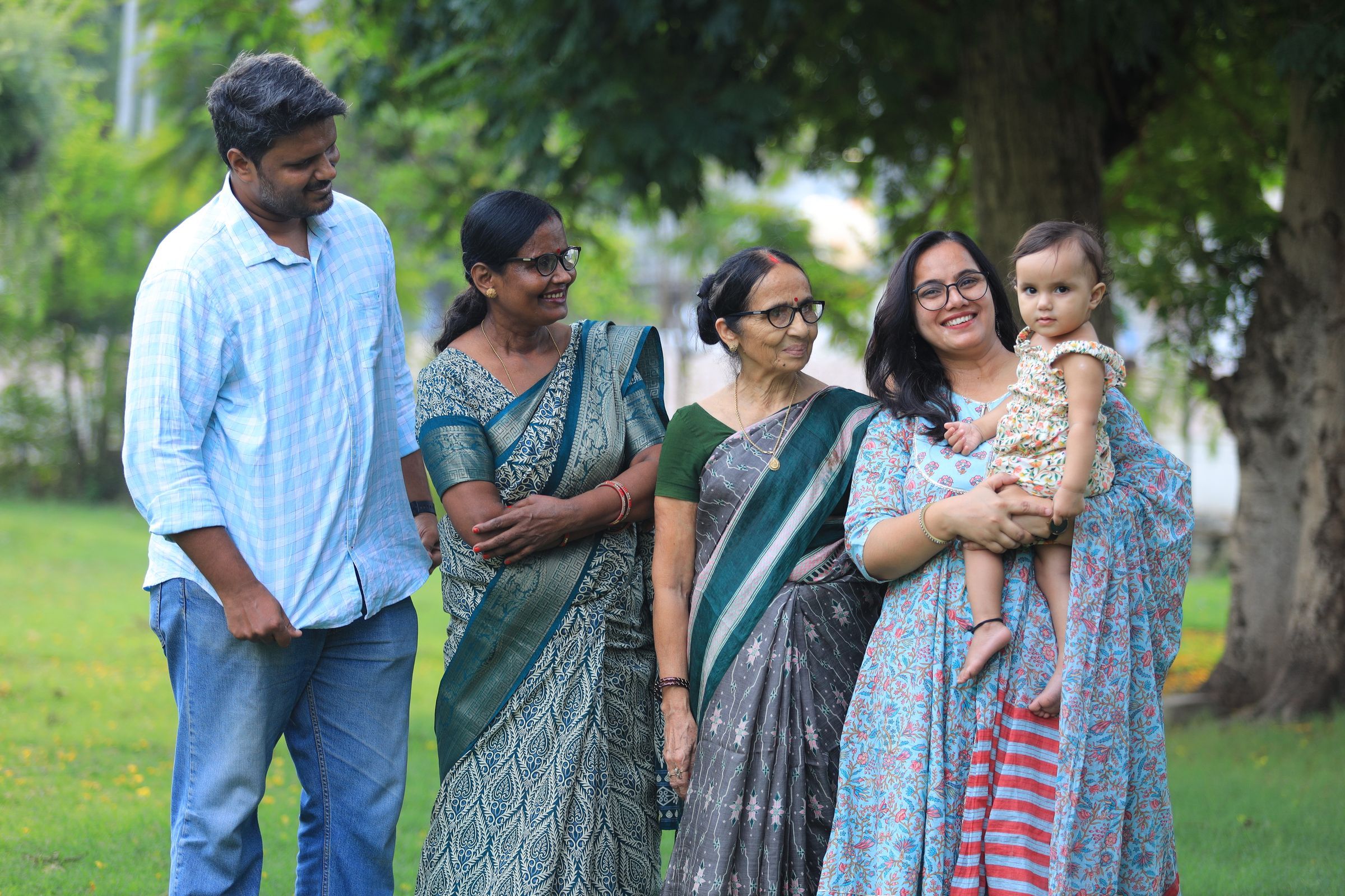 Three generations of an Indian family standing together outdoors