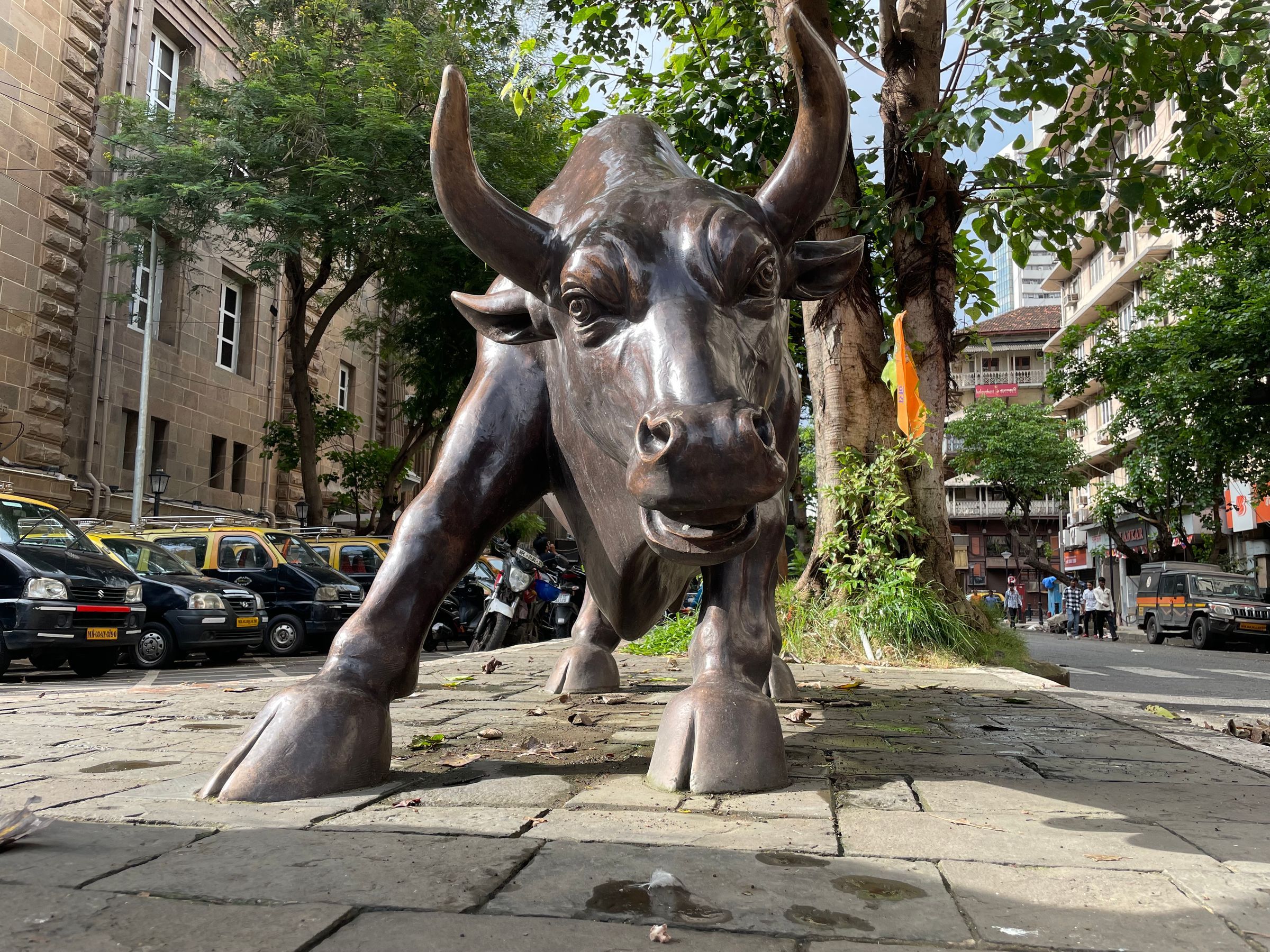 A bronze bull statue on a street corner in Mumbai